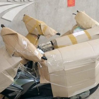 Bọc xe máy bằng bìa carton đơn giản, tiết kiệm và phù hợp cho quãng đường ngắn.